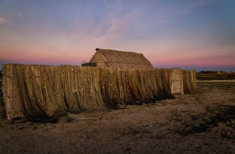 aux premières lueurs du levé de soleil, un cabanon de pêcheur construit en sanil, entouré du barrière de canisses