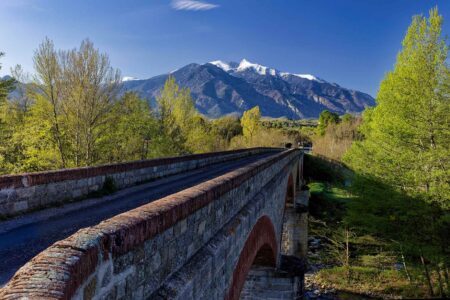le pont conduisant à Eus avec au fond le Canigou enneigé au début du printemps