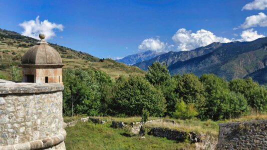 une échauguette ne premier plan de la citadelle de Mont-Louis et le paysage de montagnes au fond